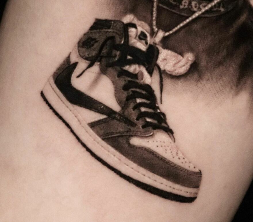 Realistic tattoo of a sneaker with detailed shading and color, showcasing flawless lifelike artistry.