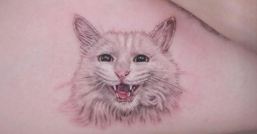 Amazingly realistic white cat portrait tattoo with open mouth, showcasing detailed artistry.