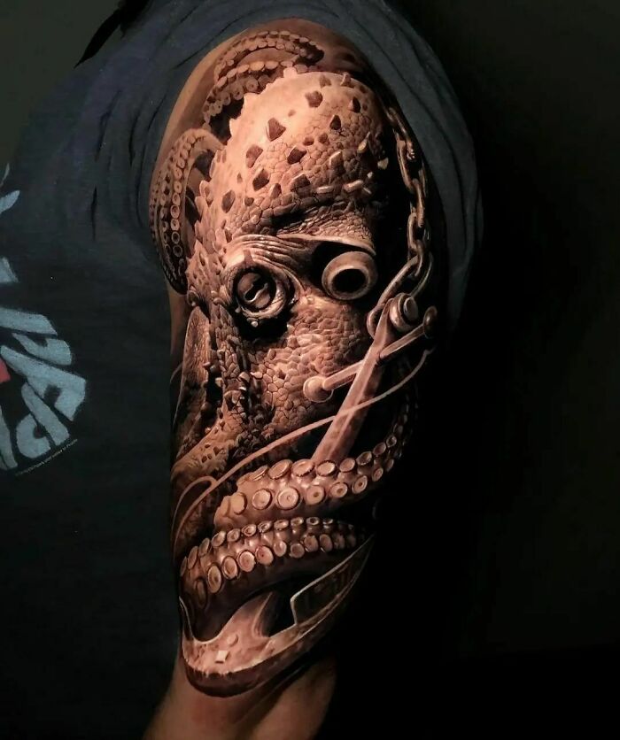 Super realistic tattoo of an octopus on a person's upper arm, showcasing intricate detail and lifelike design.