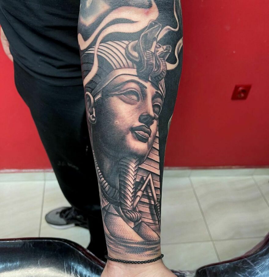 Super realistic Sphinx head tattoo on arm with intricate Egypt theme detailing.