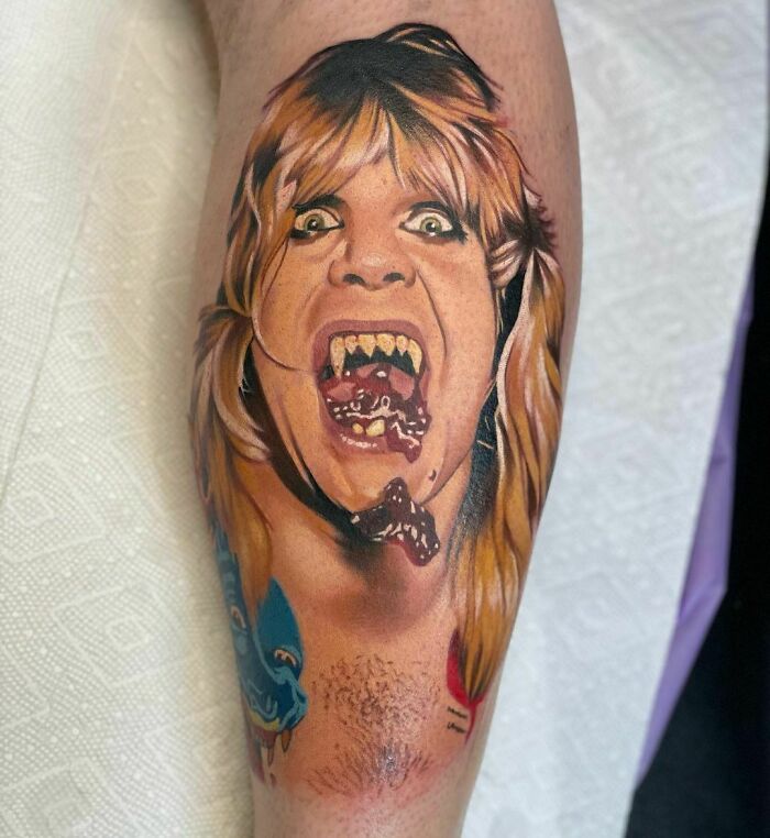 Realistic tattoo of a screaming face with detailed features on a calf.