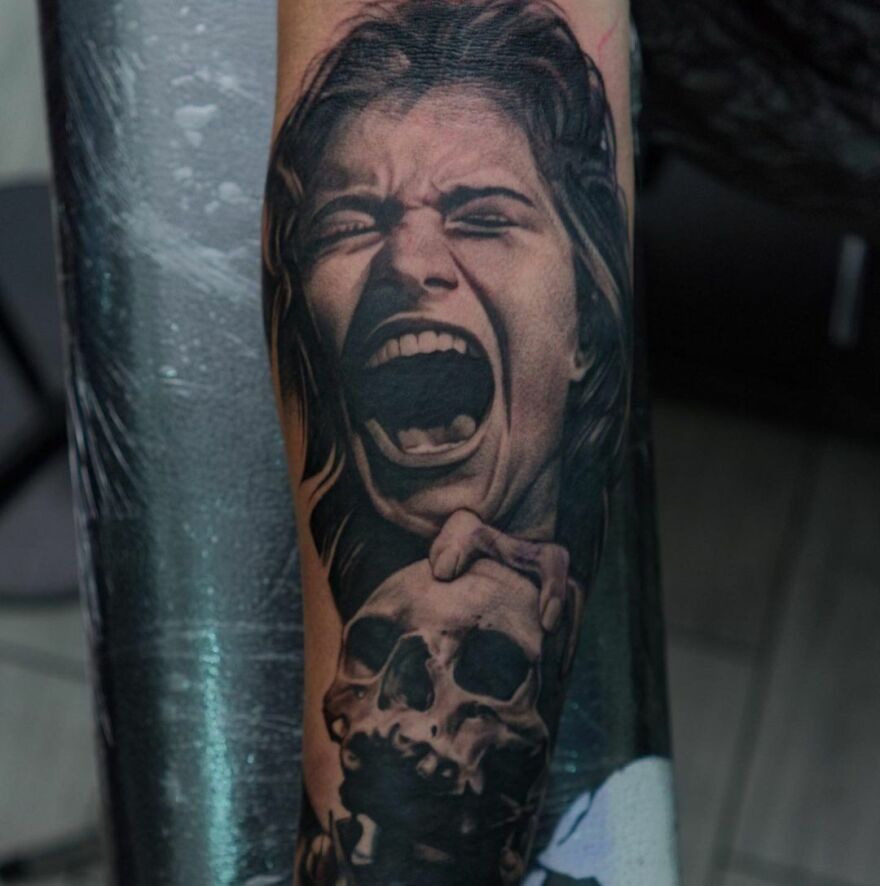 Realistic tattoo of a screaming face and skull on a forearm, showcasing intricate detail and shading.