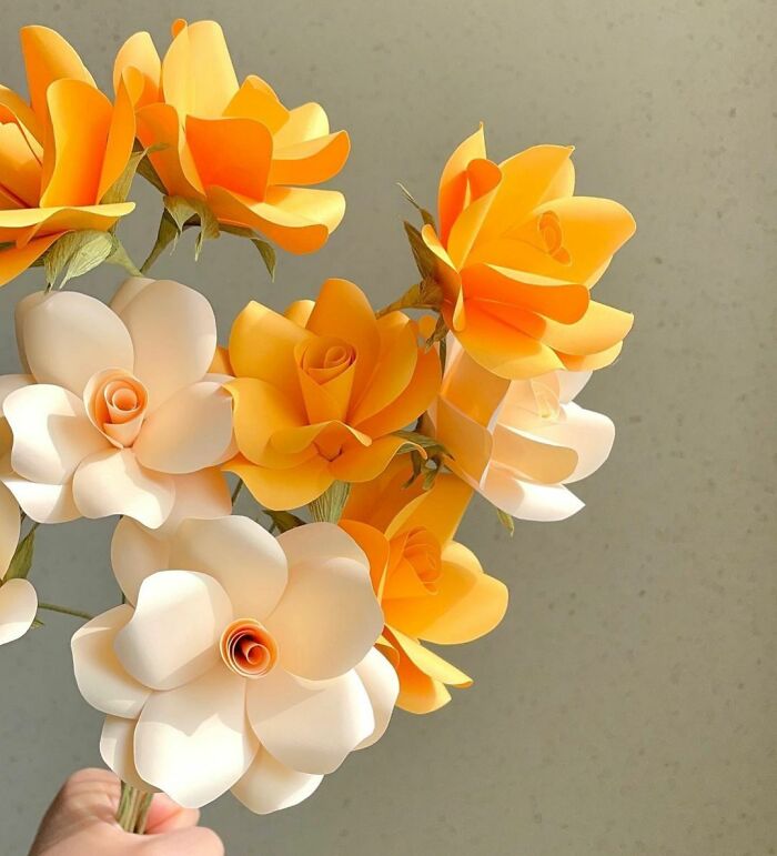 an orange and white bouquet of flowers made out of the paper