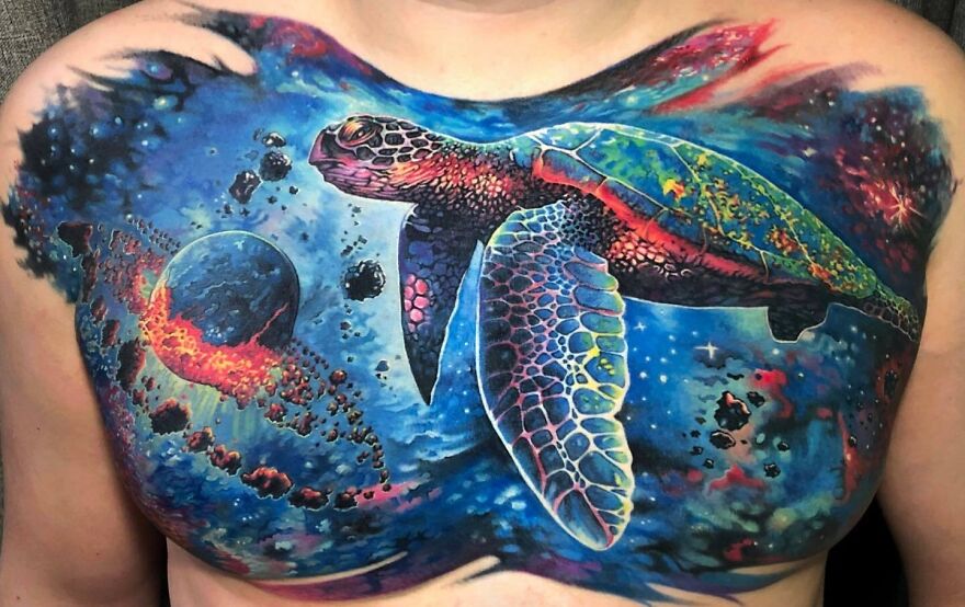 Colorful space turtle tattoo on chest, showing realistic detailing of underwater scene.