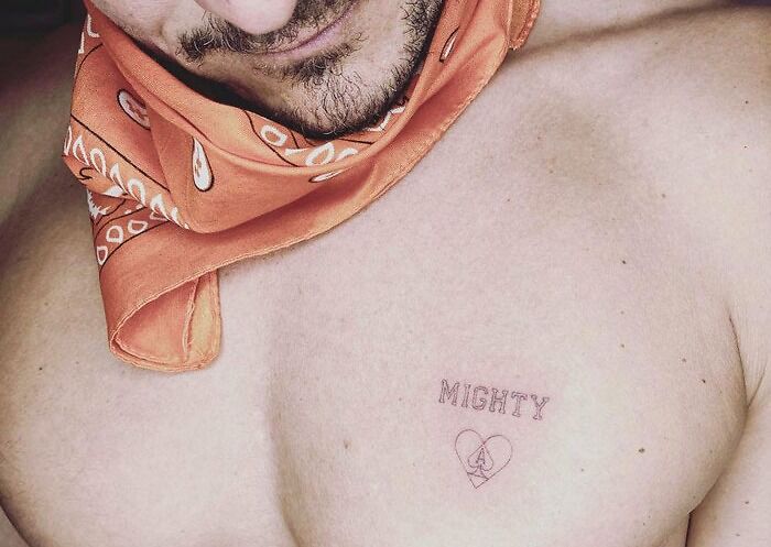 Celebrity tattoos: a chest tattoo with the word "Mighty" and a heart emblem, with a person wearing an orange bandana.