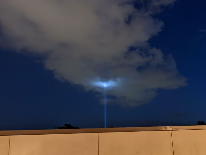 There Was A Sky Light Beaming Up Towards The Sky From The Ground Level. The Cloud Glow Makes It Seem Like An Alien Spaceship
