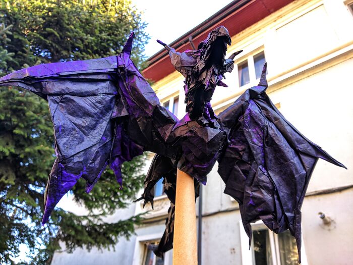 a paper purple dragon sitting on the column