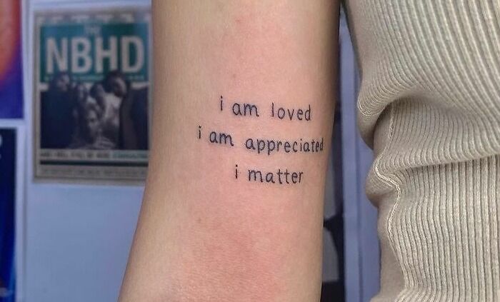 Arm with a creative word tattoo saying, "i am loved, i am appreciated, i matter," showcasing personal ink inspiration.