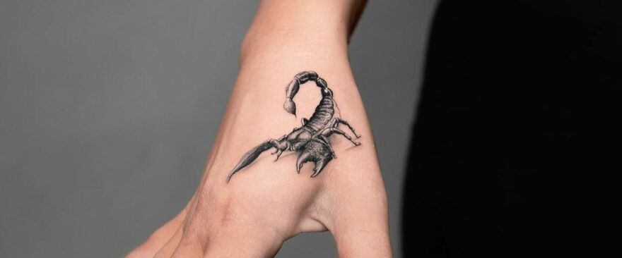 Realistic tattoo of a scorpion on a hand, showcasing detailed and lifelike artistry.
