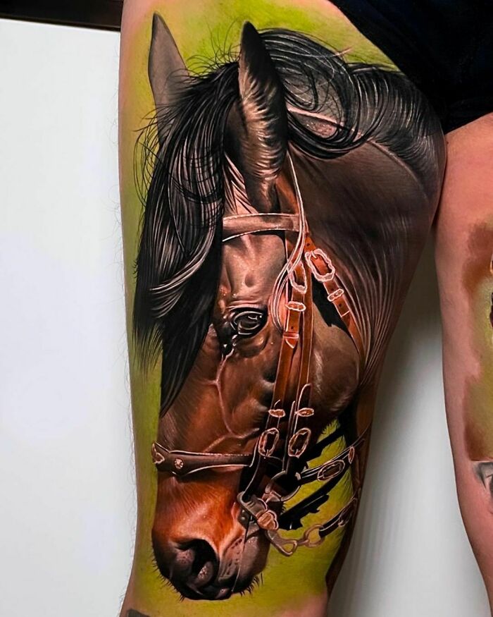 Realistic horse tattoo in vibrant colors on a person's upper arm, showcasing intricate details and shading.