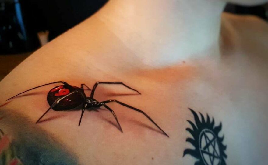 Realistic tattoo of a dark spider on a right shoulder, showcasing incredible detailing.