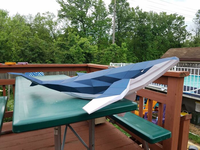 a paper white and blue whale on the table in the street
