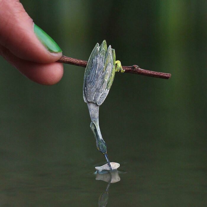 a little colorful bird with a fish in its beak 