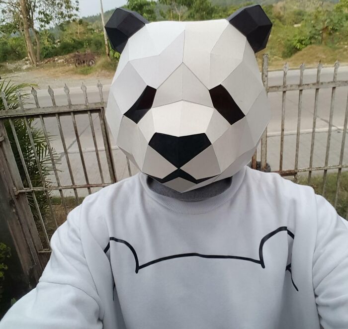 a panda head origami on the head of a man