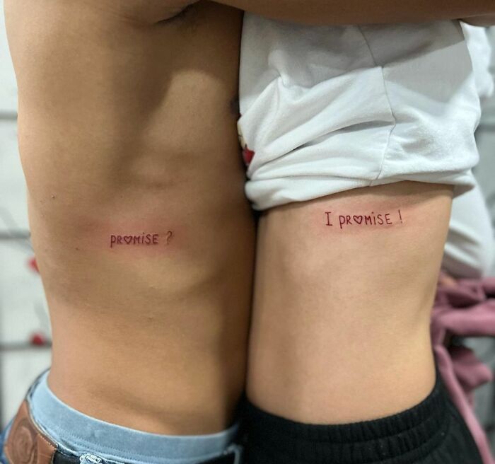 Matching tattoos on two people’s sides reading, "promise?" and "I promise!" illustrating commitment.