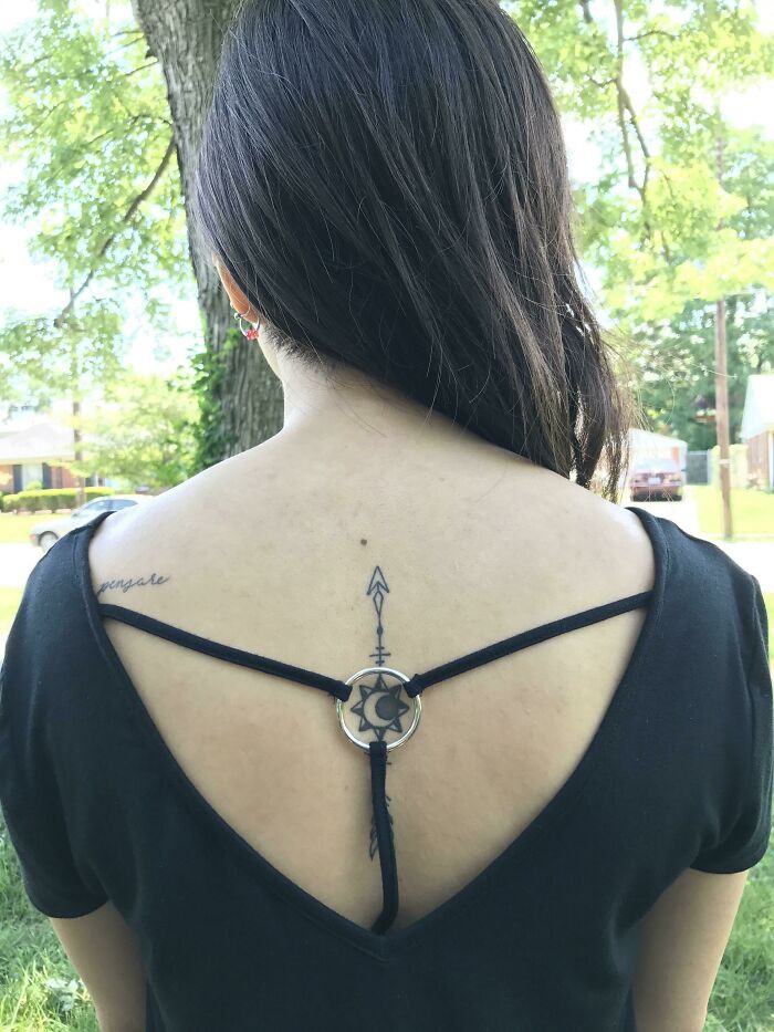 Back tattoo perfectly aligned with the strap design, creating an unexpected visual match.