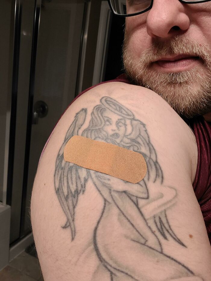 Tattoo with a bandage perfectly matching the angel design on a man's arm.