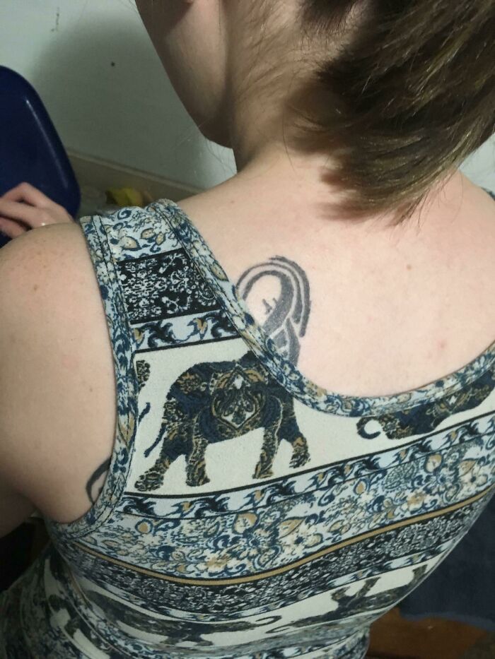 Woman with elephant tattoo, wearing a patterned top that unintentionally aligns with the tattoo, highlighting a perfect match.