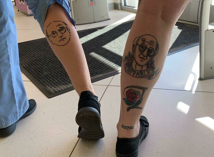 Two people with matching tattoos of the same face and text, standing side by side, creating an accidental perfect match.
