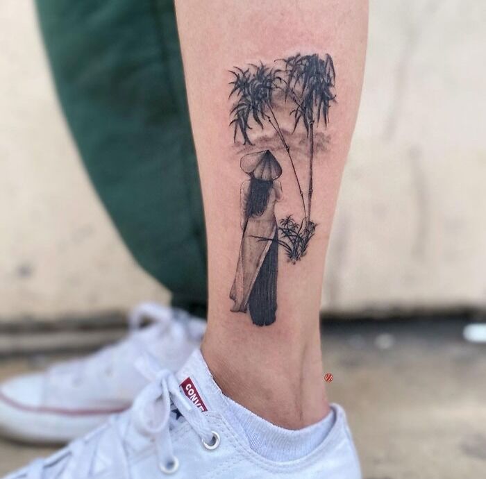 Calf tattoo featuring a serene scene of a figure in traditional attire with bamboo trees, showcasing cool calf tattoo ideas.