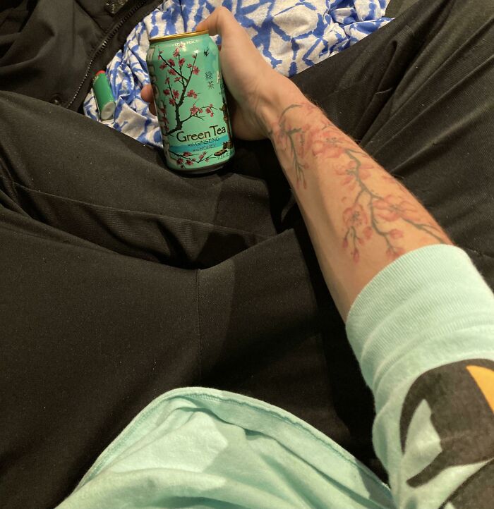 Tattoo of cherry blossoms accidentally matching with design on a green tea can.