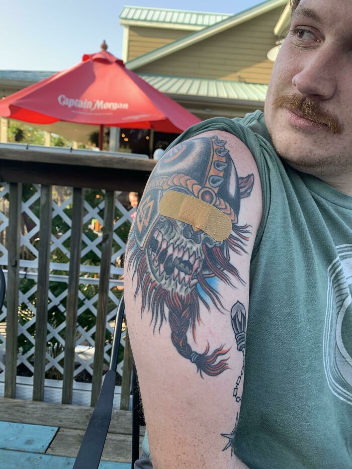 A man with a Viking tattoo covered by a band-aid, humorously matching the situation.