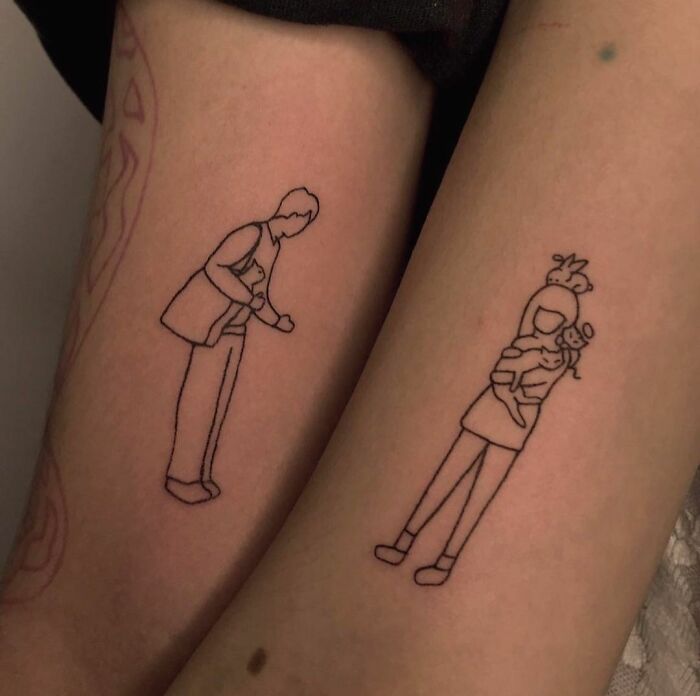 Matching tattoos on arms depict a couple holding cats, symbolizing special bonds.