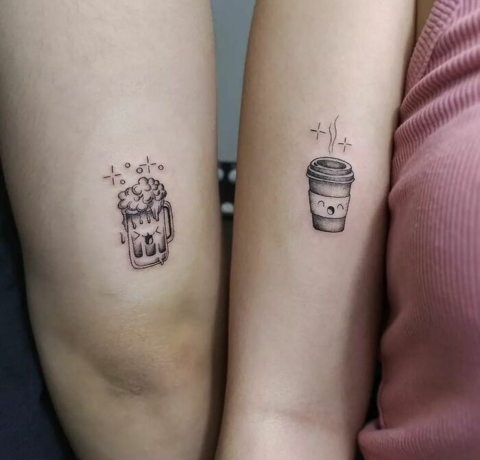 Matching tattoos of a smiling beer mug and coffee cup on two arms, symbolizing friendship and connection.