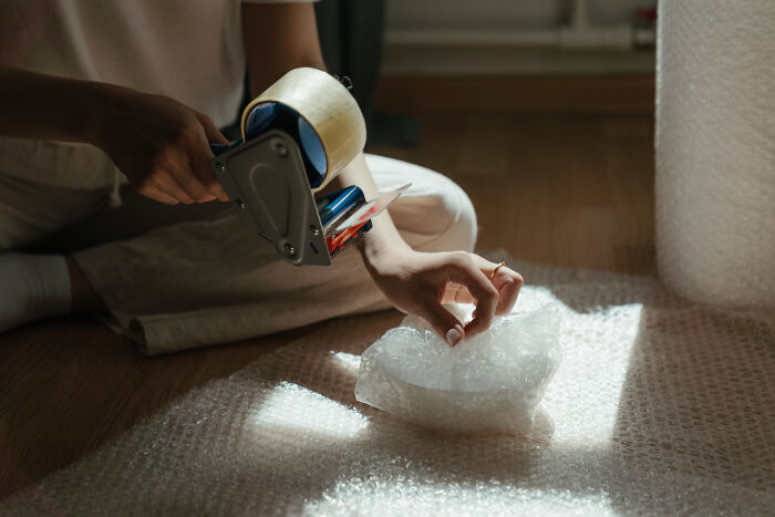 A woman is packing with bubble wrap