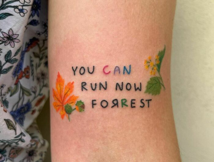 Self-love tattoo with "You can run now Forrest" phrase and leaf designs.