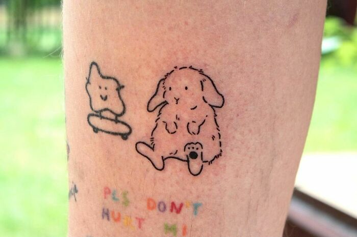 Whimsical self-love tattoo with playful characters and colorful text.