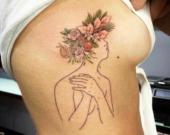 Self-love tattoo featuring a woman with flowers in her head, symbolizing personal empowerment and beauty.
