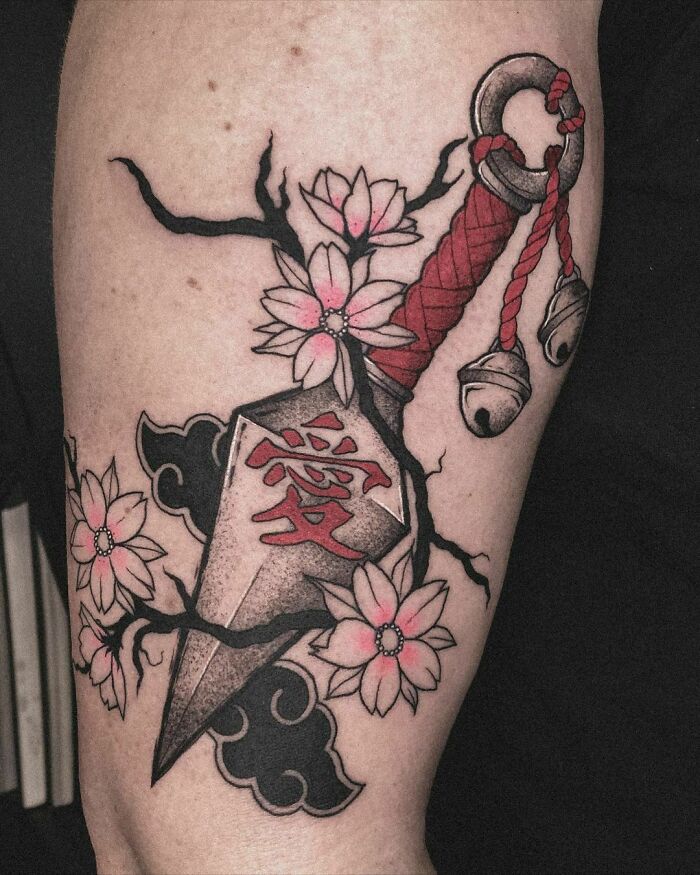 Self-love tattoo of a kunai entwined with flowers, showcasing personal strength and beauty.
