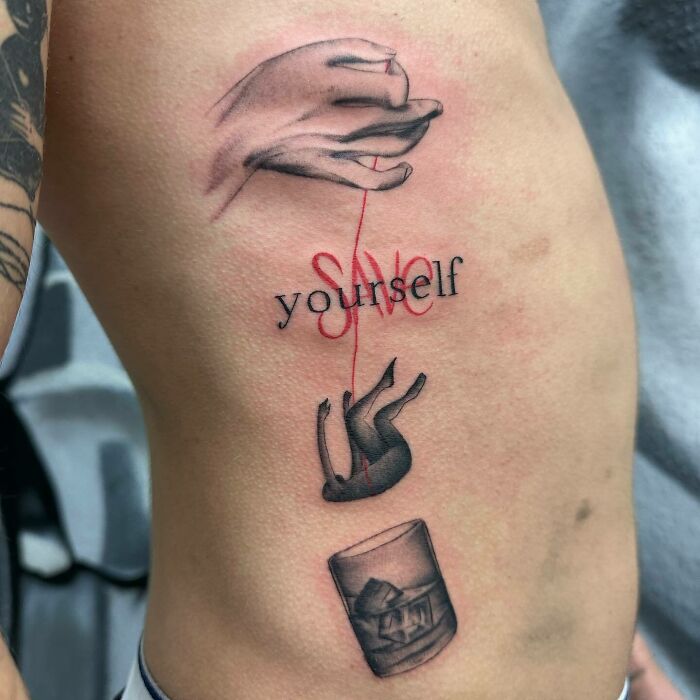 Tattoo of a hand holding a red thread attached to the words "save yourself" with a falling figure and drink glass. Self-love tattoo.