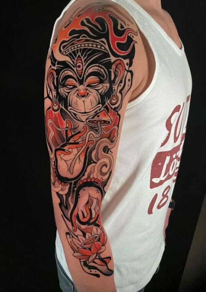 Colorful monkey tattoo embracing simplicity and realism on a man's upper arm.