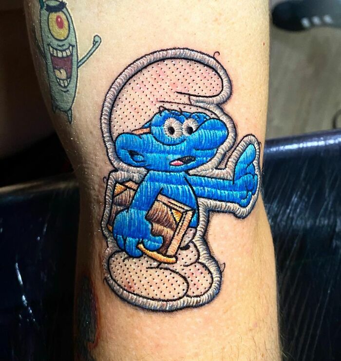 Tattoo of a cartoon character in embroidery style by Eduardo Lozano, showcasing new dimension in tattooing.