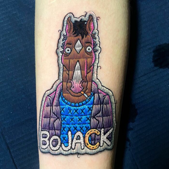 Tattoo of BoJack Horseman by Eduardo Lozano, featuring embroidery style on an arm.