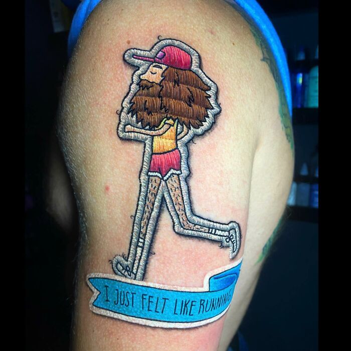 Tattoo by Eduardo Lozano of a character running, with a banner reading "I just felt like running," showcasing unique dimension work.