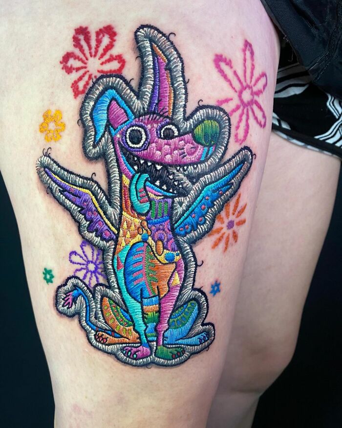 Vibrant embroidered animal tattoo by Eduardo Lozano, showcasing intricate detail and bold colors on skin.