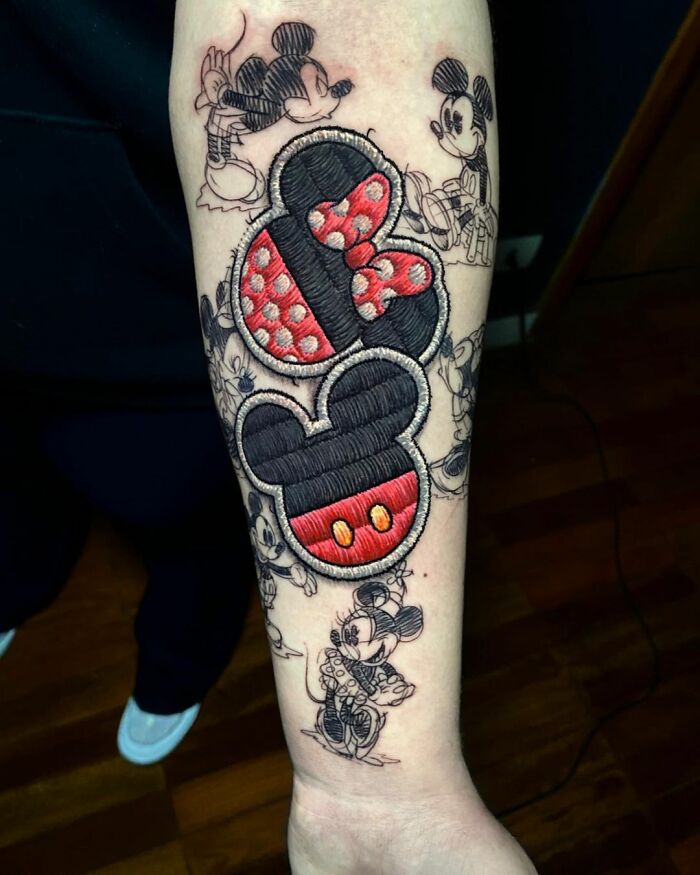 Innovative embroidery-style tattoo featuring iconic mouse characters, showcasing Eduardo Lozano's unique tattooing dimension.
