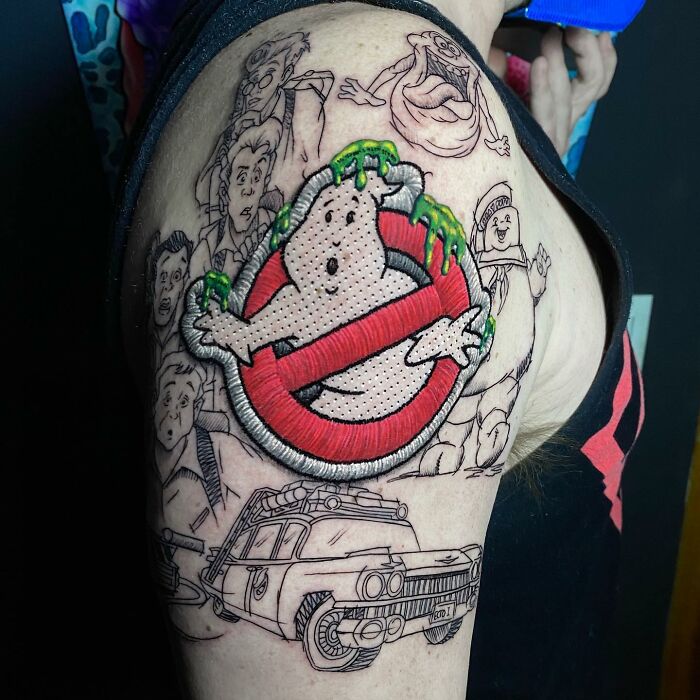 Ghostbusters-themed tattoo by Eduardo Lozano, featuring vibrant 3D effects on a shoulder.