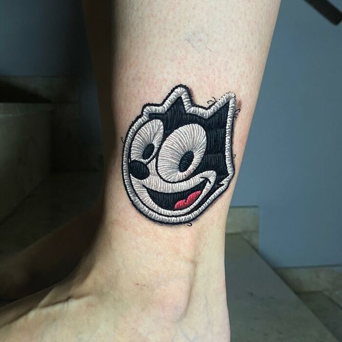 Tattoo resembling a cat character by Eduardo Lozano, showcasing a new dimension in his tattoo art style.