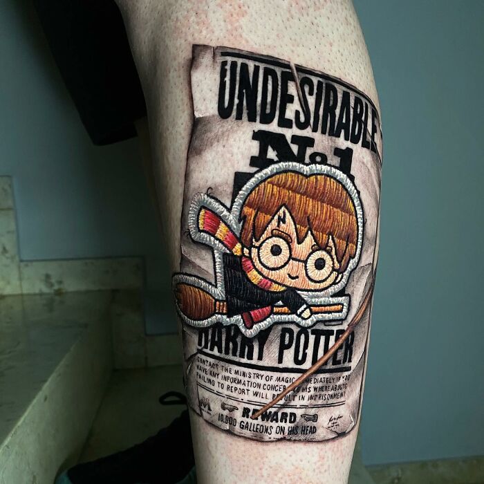 Tattoo by Eduardo Lozano featuring a cartoon character Harry Potter on a wanted poster, showcasing unique tattooing style.