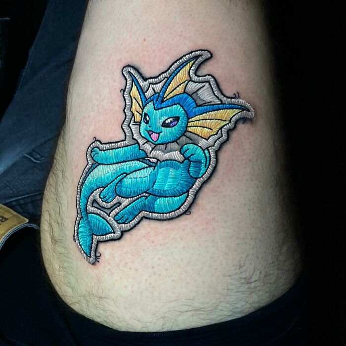 Embroidered-style tattoo featuring a vibrant blue water creature, showcasing Eduardo Lozano's innovative tattooing technique.