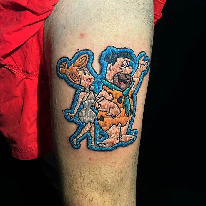Tattoo of cartoon characters on leg, showcasing Eduardo Lozano's new dimension in tattooing.