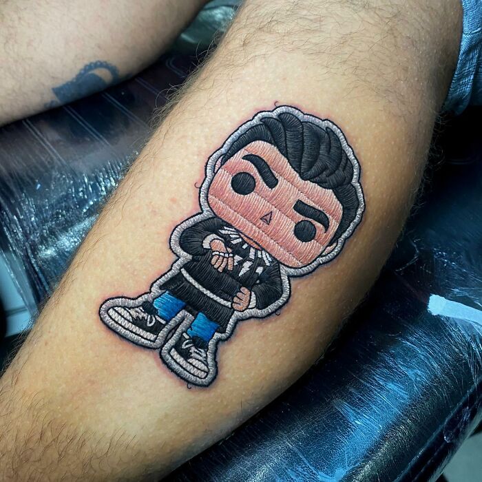Tattoo of a stylized character on a person's arm, showcasing Eduardo Lozano's new dimension style in tattooing.