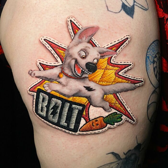 Tattoo by Eduardo Lozano featuring a cartoon dog with "Bolt" text in a vibrant, colorful design.