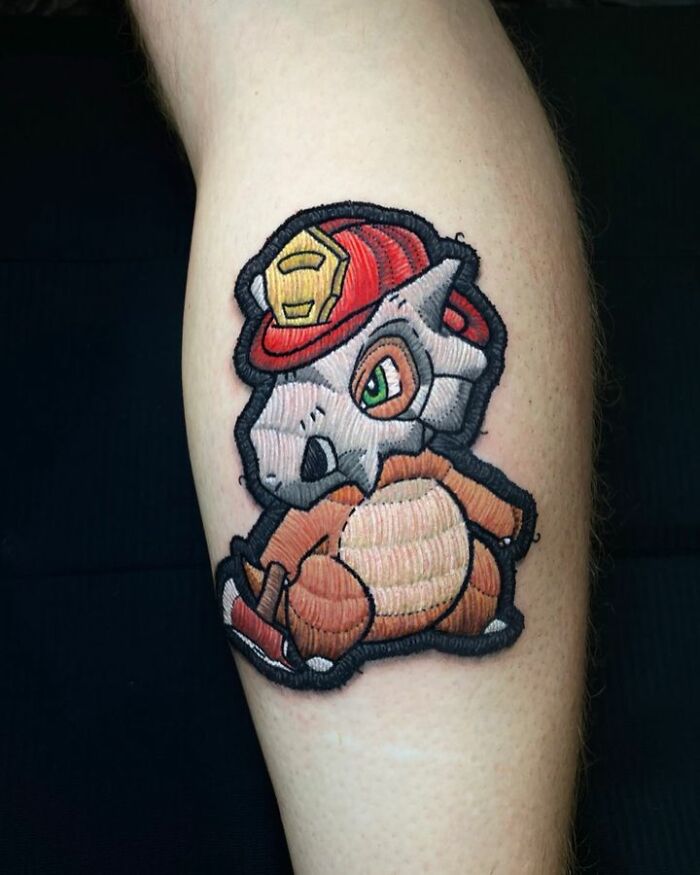 Tattoo of Cubone wearing a red helmet, showcasing Eduardo Lozano's unique 3D embroidery style.