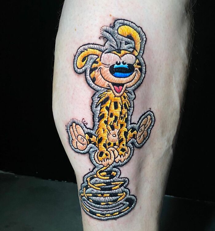 Tattoo by Eduardo Lozano of a cartoon character with spring legs in vibrant colors on a person's leg.