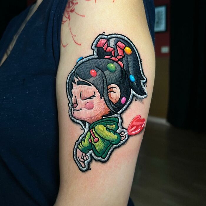 3D effect tattoo in vibrant colors on an arm, showcasing a playful cartoon style by Eduardo Lozano.